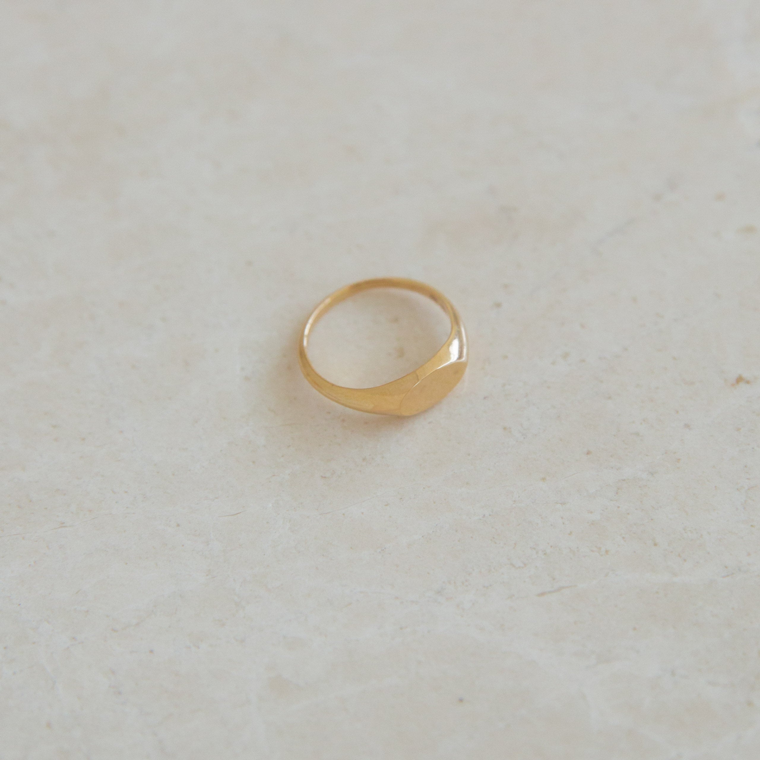 Gold ring on a light beige background