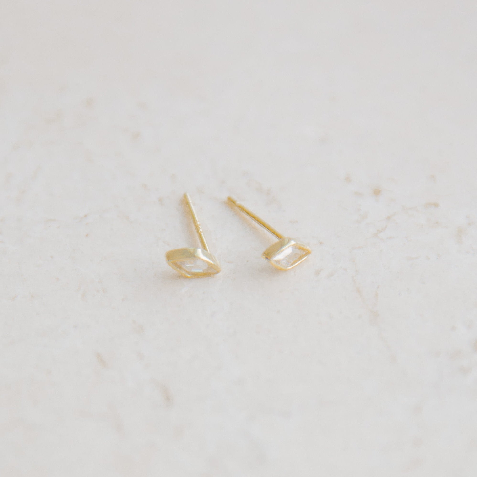 Fashion-forward woman pairing marquise studs with a modern layered necklace look