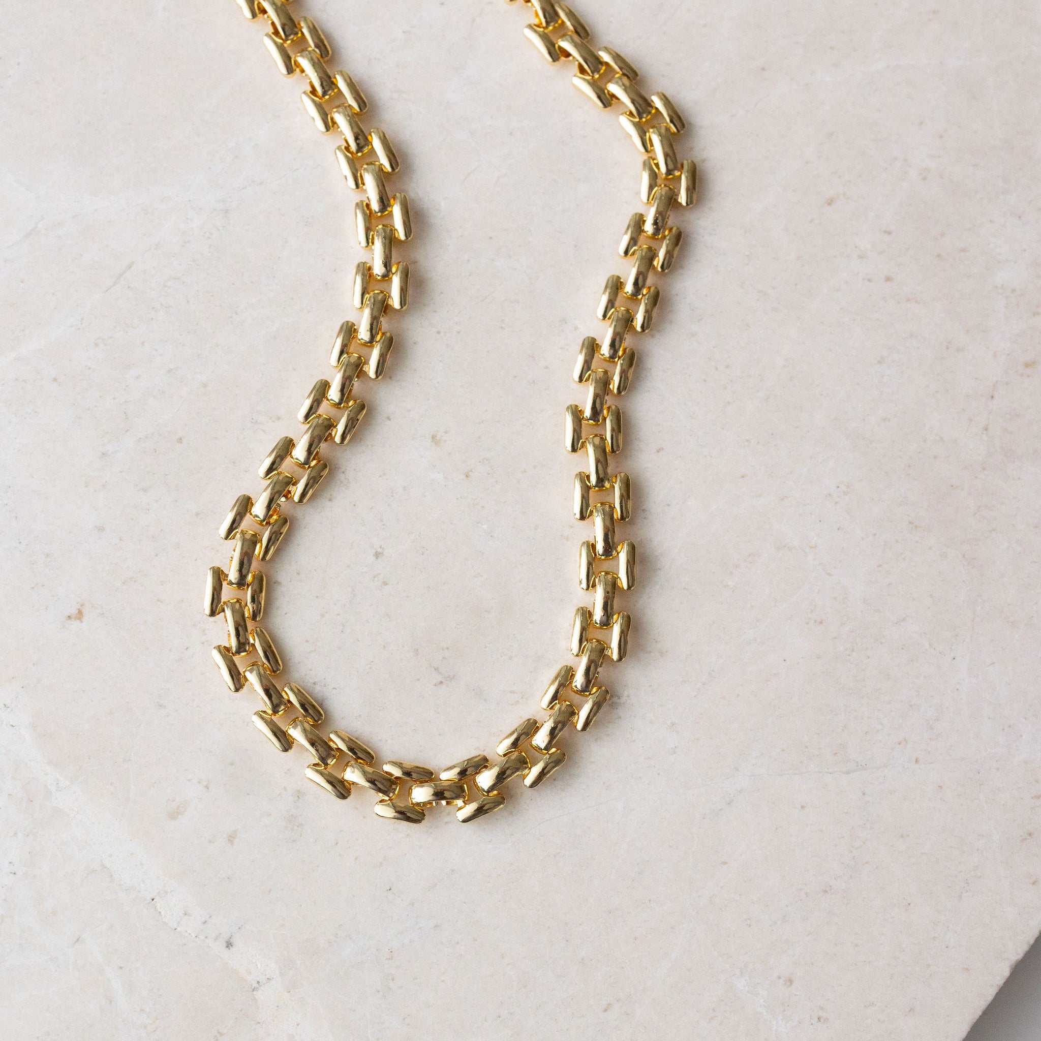 A close-up view of the 14k gold filled Ray chain necklace showcasing its thick, 5mm textured link design.