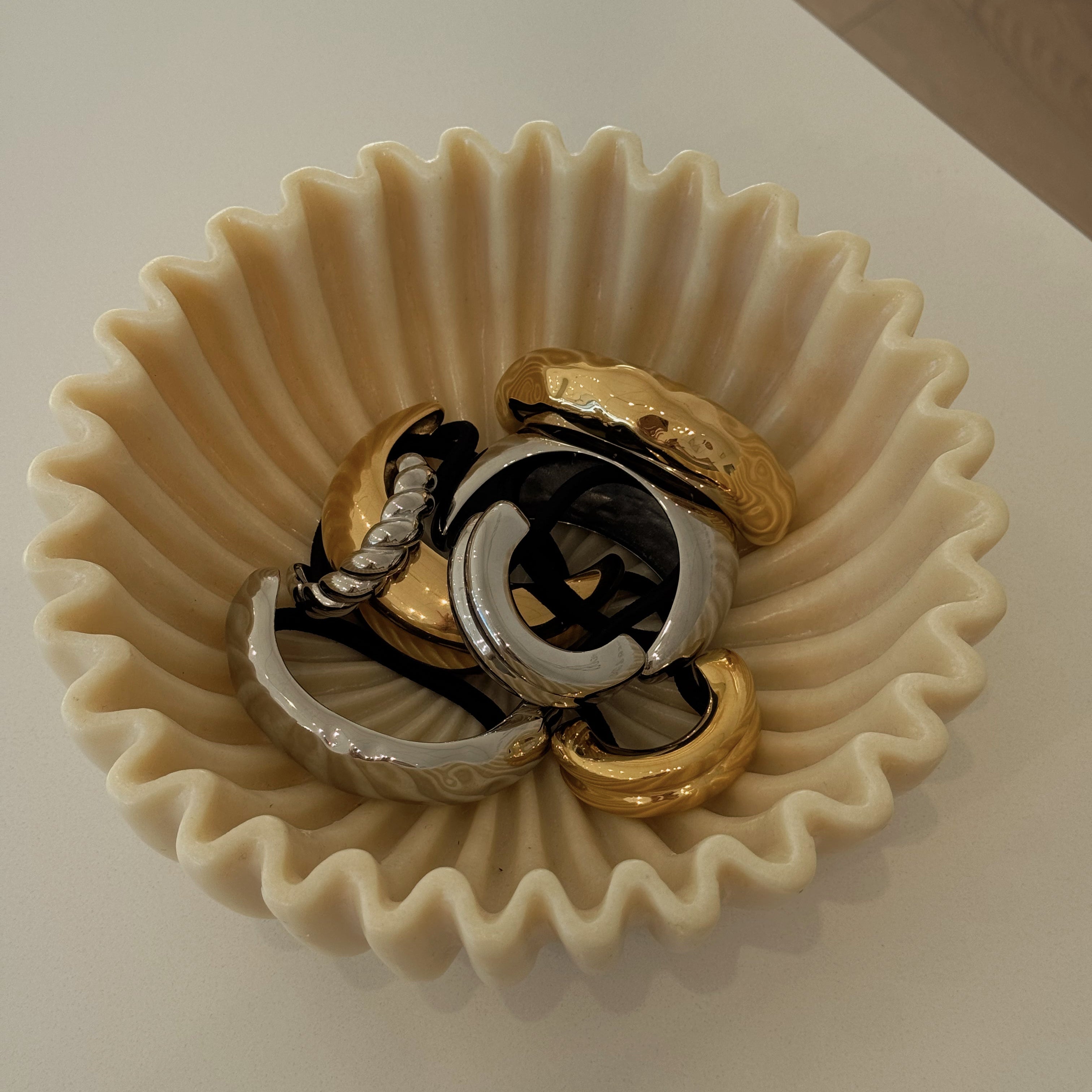 Set of rings in a decorative beige bowl on a light background