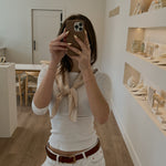 Person taking a mirror selfie in a store with shelves and products.